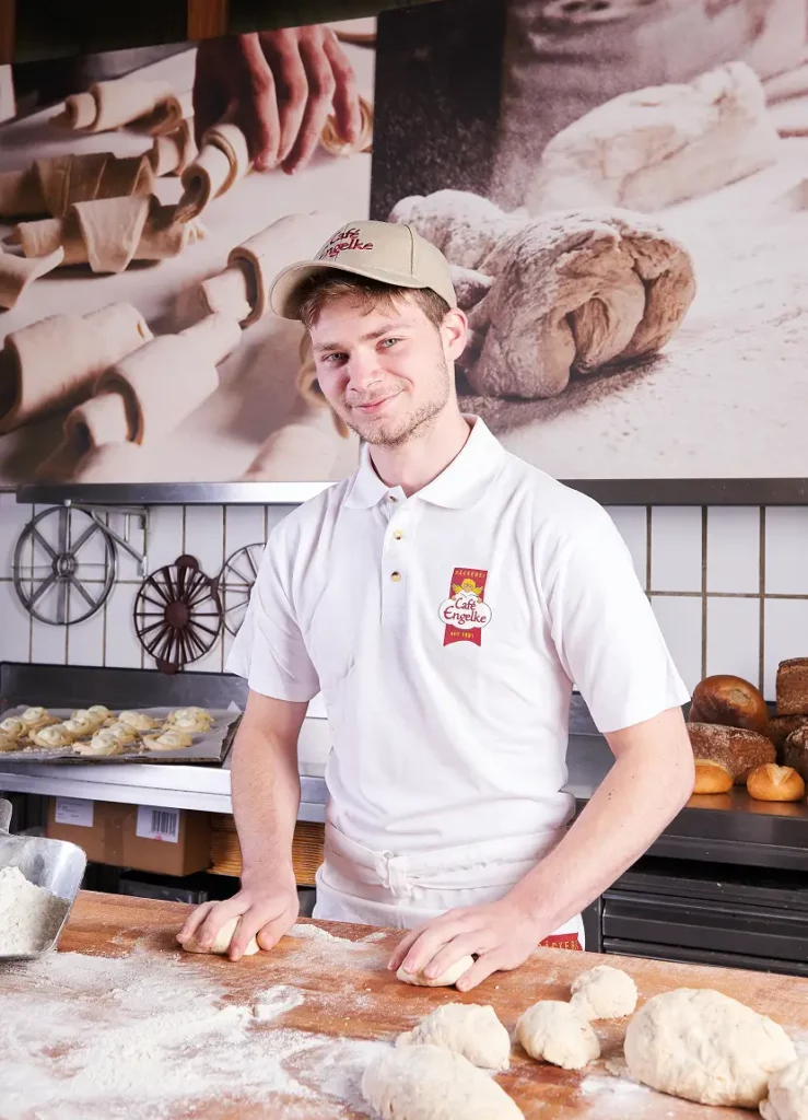 Ein junger Bäcker von Café Engelke arbeitet an den Brötchen des Tages